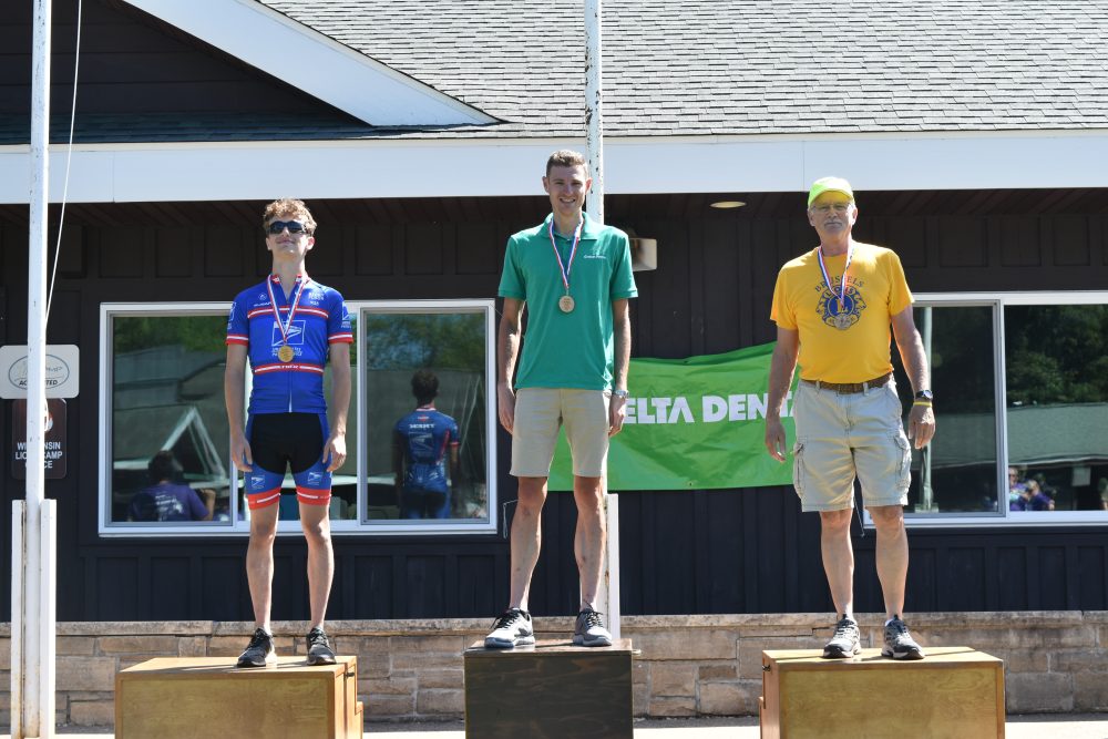 Participants standing on the awards stand after receiving medals at the Hustle S'more for Lions Camp