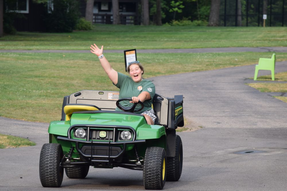 Lions Camp Staff driving a gator