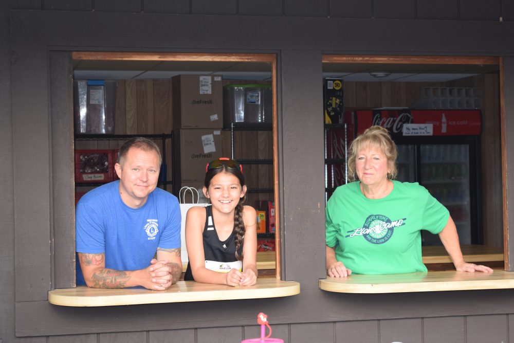 Three people in the window of trading post