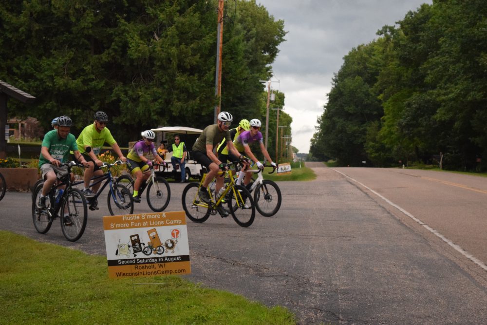 Photo of start of 15 mile bike race with bikers pulling out onto the road